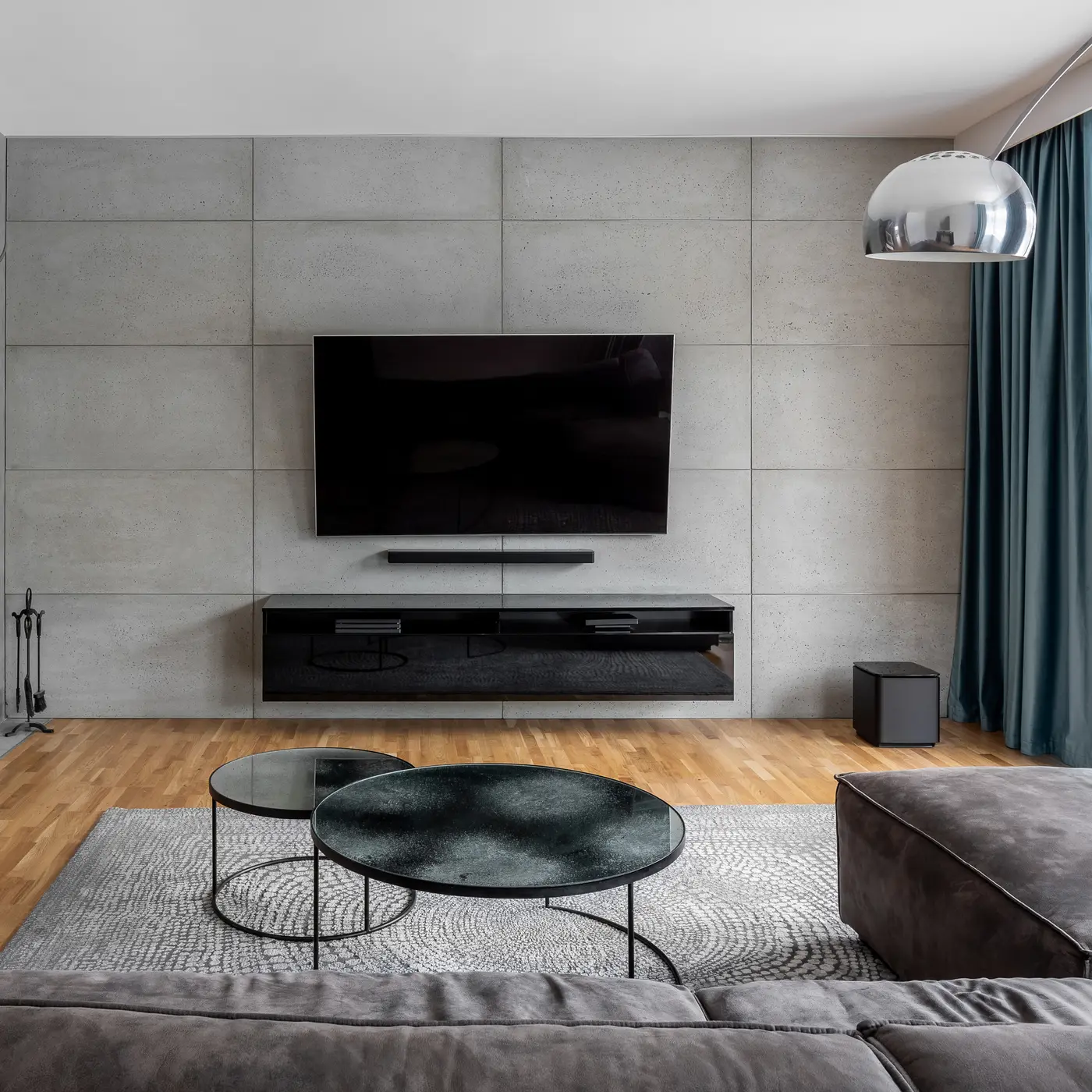 Living room with gray cement wall and wall mounted tv